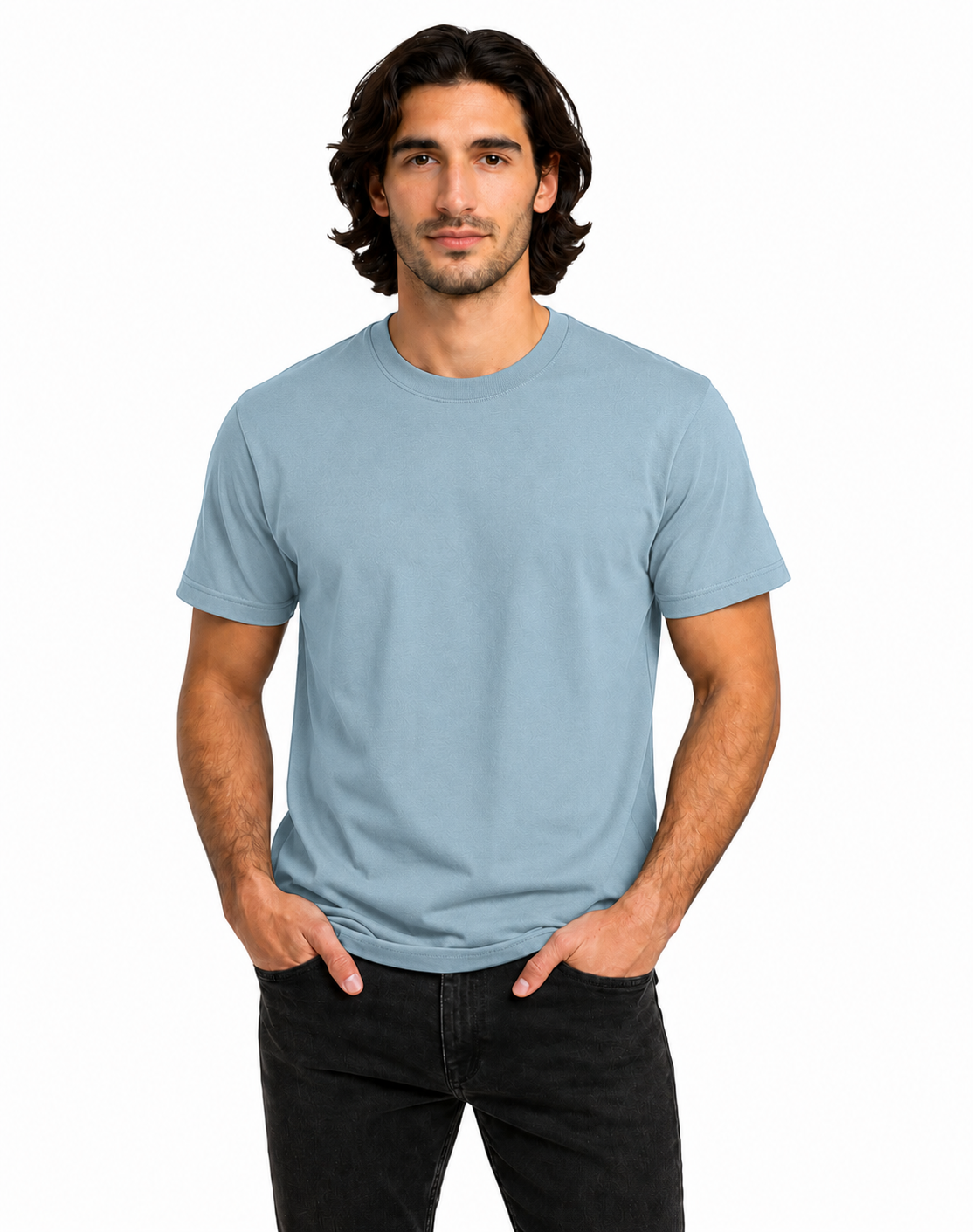 A man wearing a light blue crew-neck t-shirt and black jeans, standing against a plain white background.