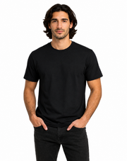 A man wearing a plain black short-sleeve crewneck t-shirt and dark jeans, standing against a solid white background.