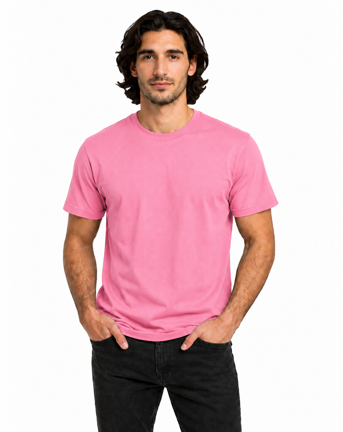 A man with dark hair modeling a solid pink crew-neck t-shirt and black jeans against a plain white background.