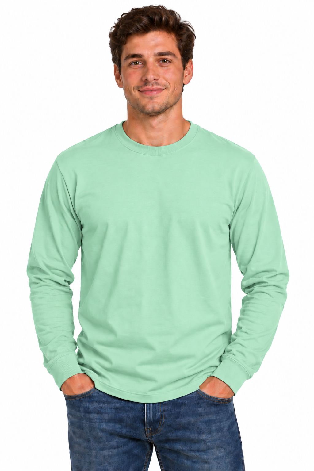 A man wearing a light mint green long-sleeve crewneck t-shirt and blue jeans, standing against a plain white background.