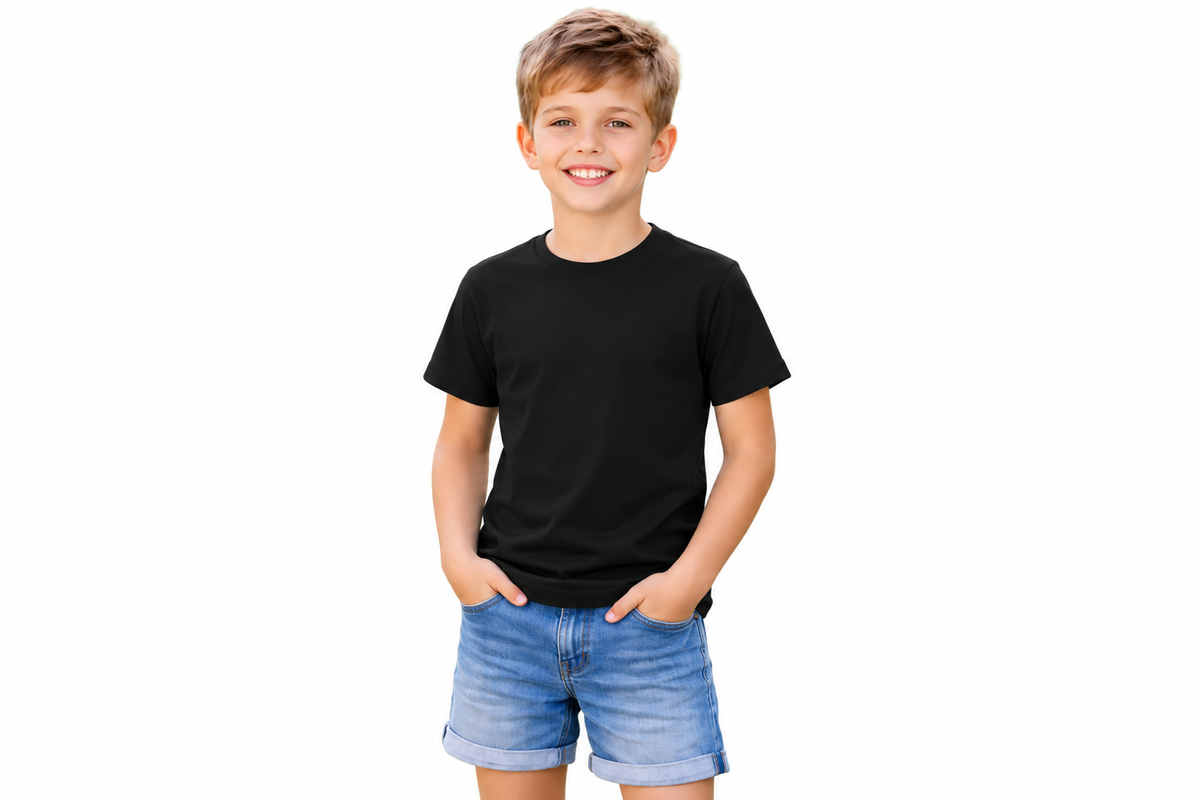 A young boy smiling and posing in a plain black short-sleeve t-shirt and blue denim shorts against a solid white background.
