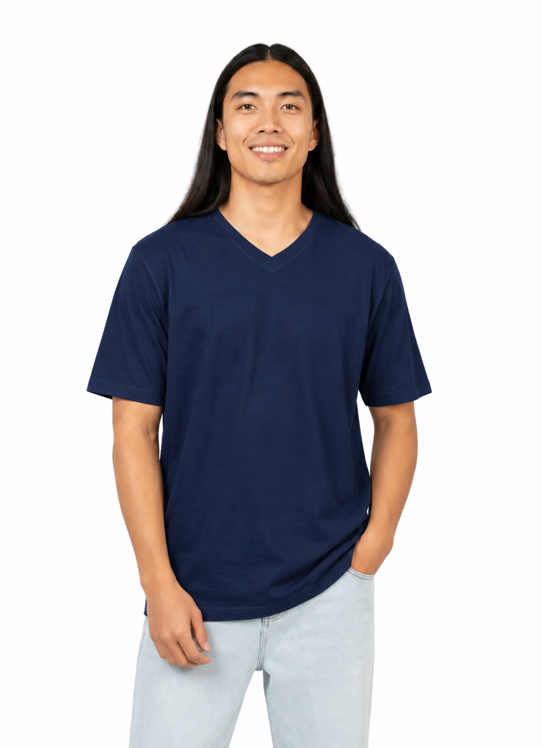 A man with long black hair wearing a navy blue v-neck t-shirt and light wash jeans, standing against a solid white background.