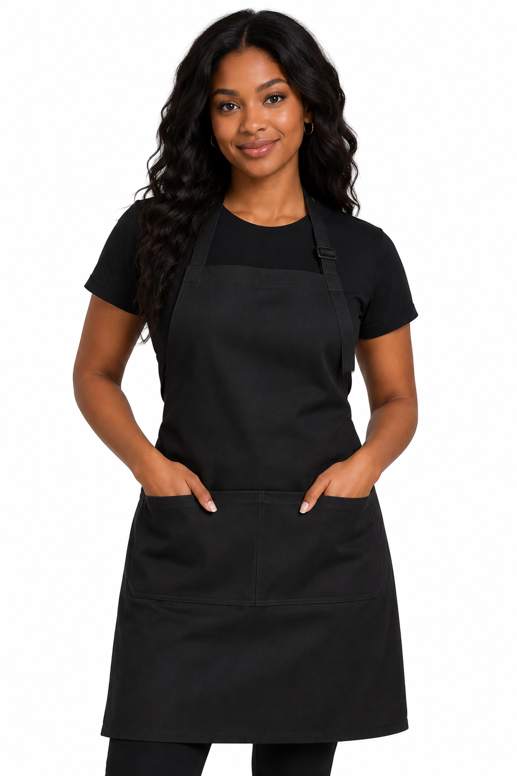 A woman modeling a black bib apron with two front pockets over a black t-shirt, photographed against a solid white background.