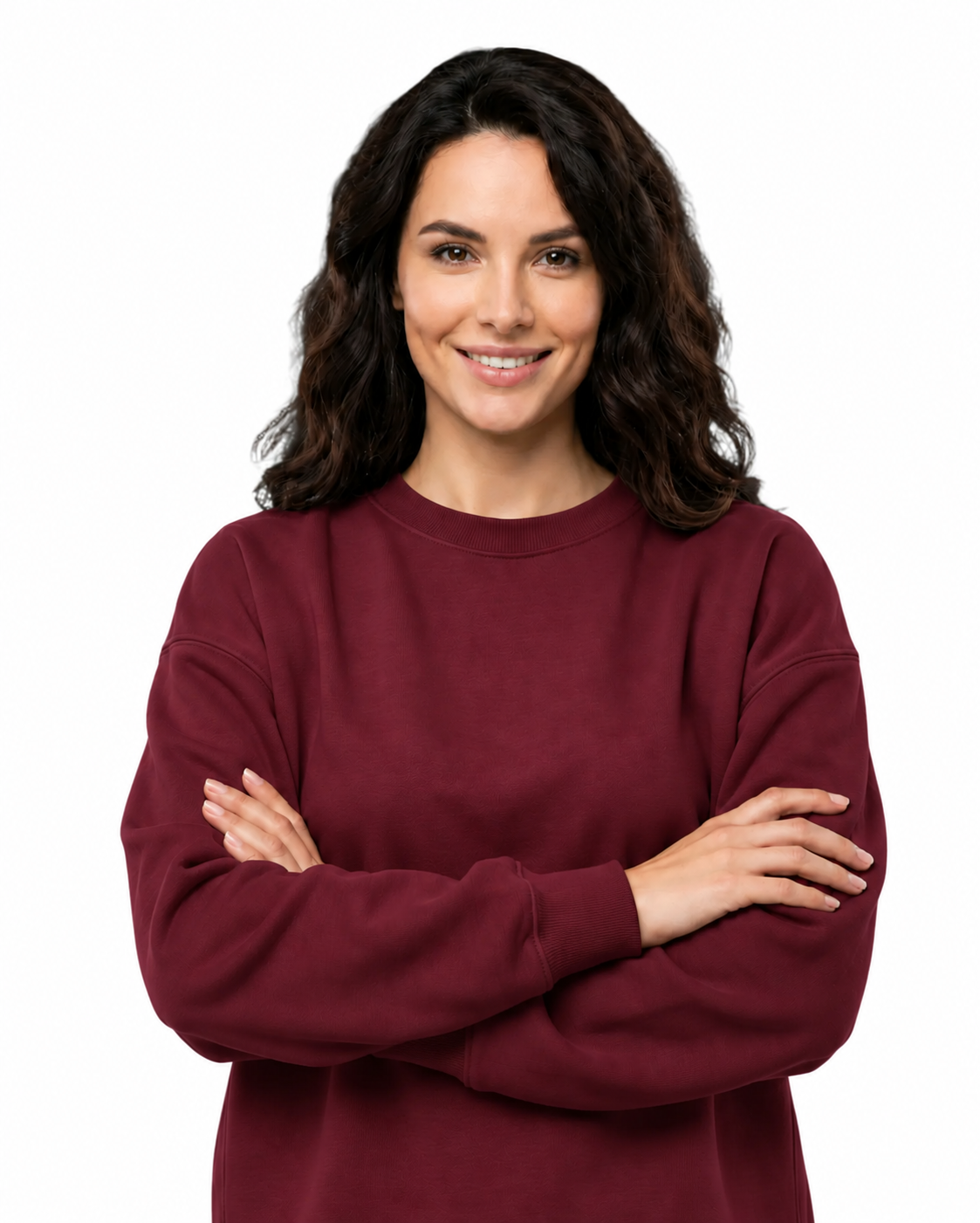 A woman with dark wavy hair wearing a crewneck sweatshirt in burgundy, standing with her arms crossed against a solid white background.