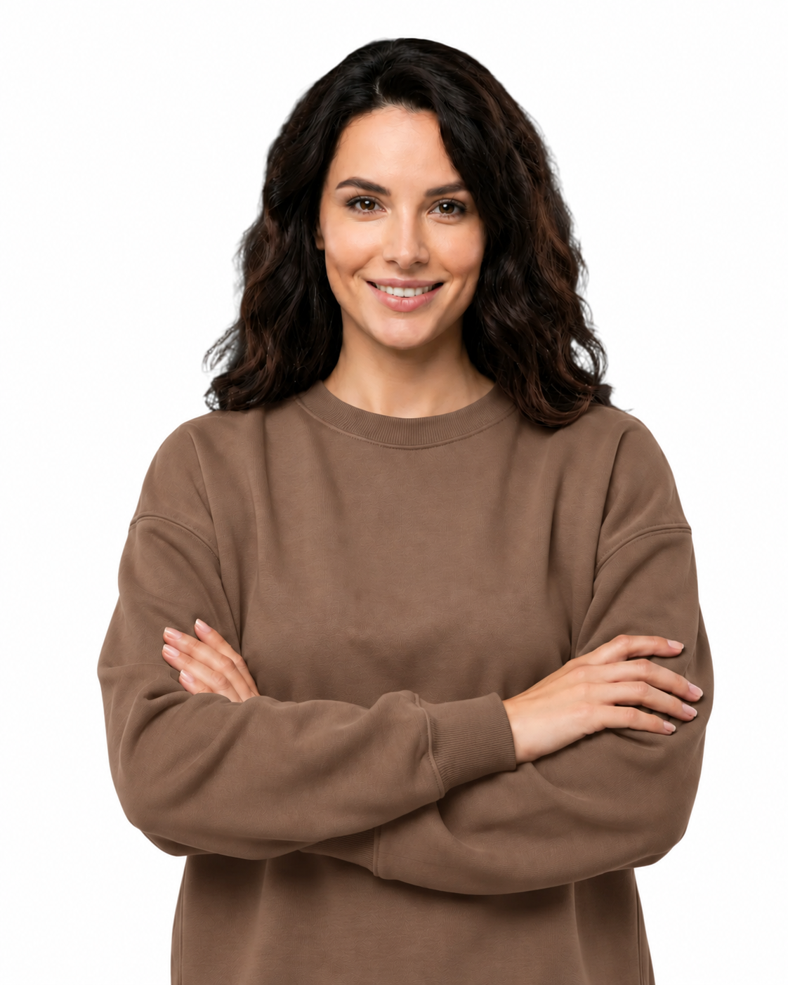 A woman with dark wavy hair wearing a brown crewneck sweatshirt, standing with her arms crossed against a solid white background.