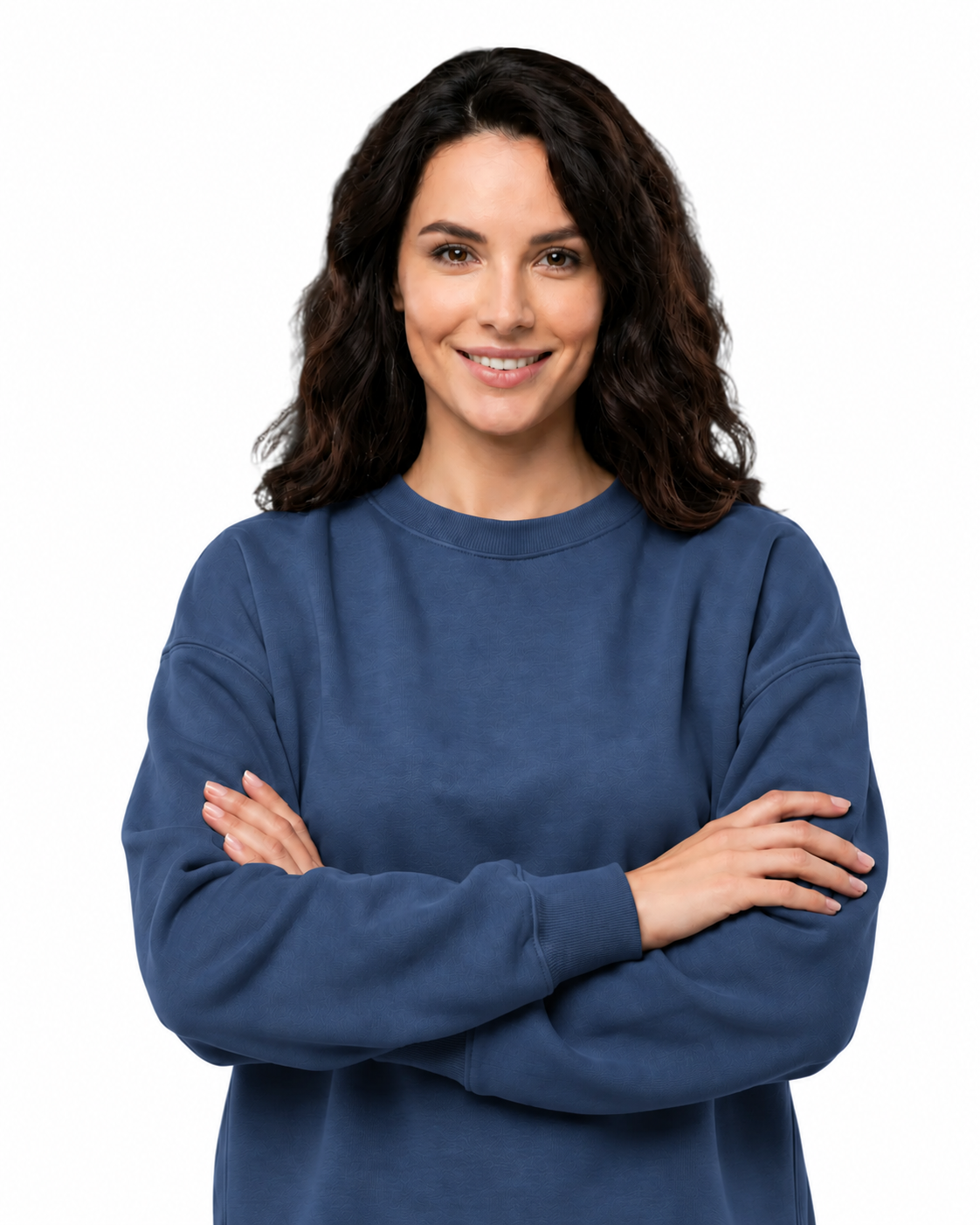A woman with dark wavy hair wearing a navy blue crewneck sweatshirt, standing with her arms crossed against a solid white background.