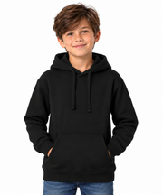 A young boy with brown hair wearing a black pullover hoodie and blue jeans, standing against a solid white background.
