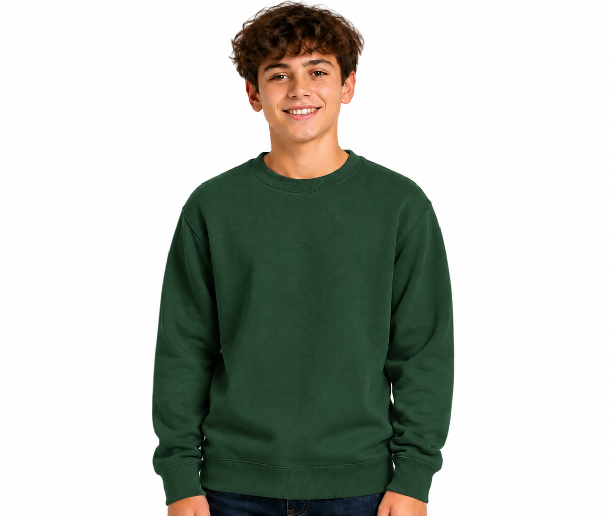 A smiling young man with curly brown hair wearing a dark forest green crewneck sweatshirt and dark blue jeans, standing against a solid white background.