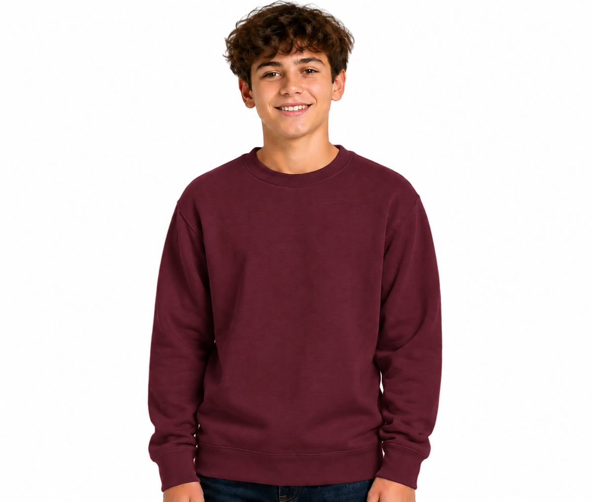 A smiling young man wearing a crewneck sweatshirt in maroon, paired with dark blue jeans, photographed against a solid white background.
