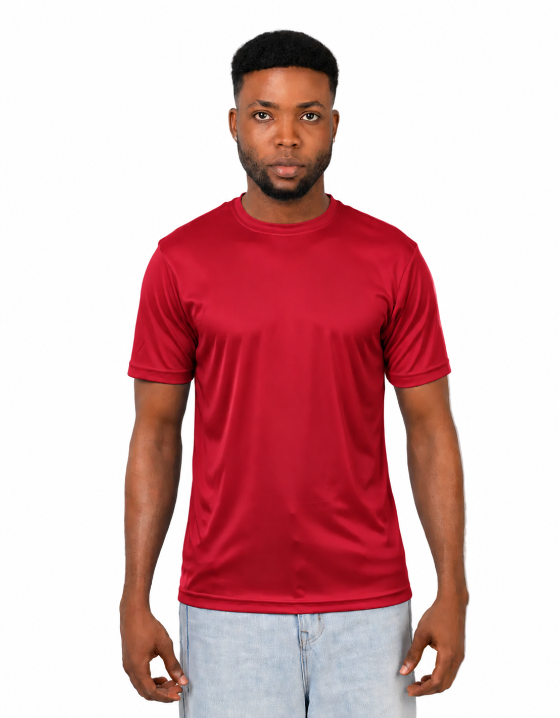 A man wearing a solid red short-sleeve crewneck athletic t-shirt and light wash jeans, standing against a plain white background.