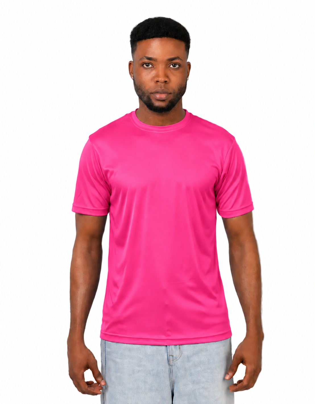 A man wearing a bright pink short-sleeve crewneck t-shirt and light blue jeans, standing against a solid white background.