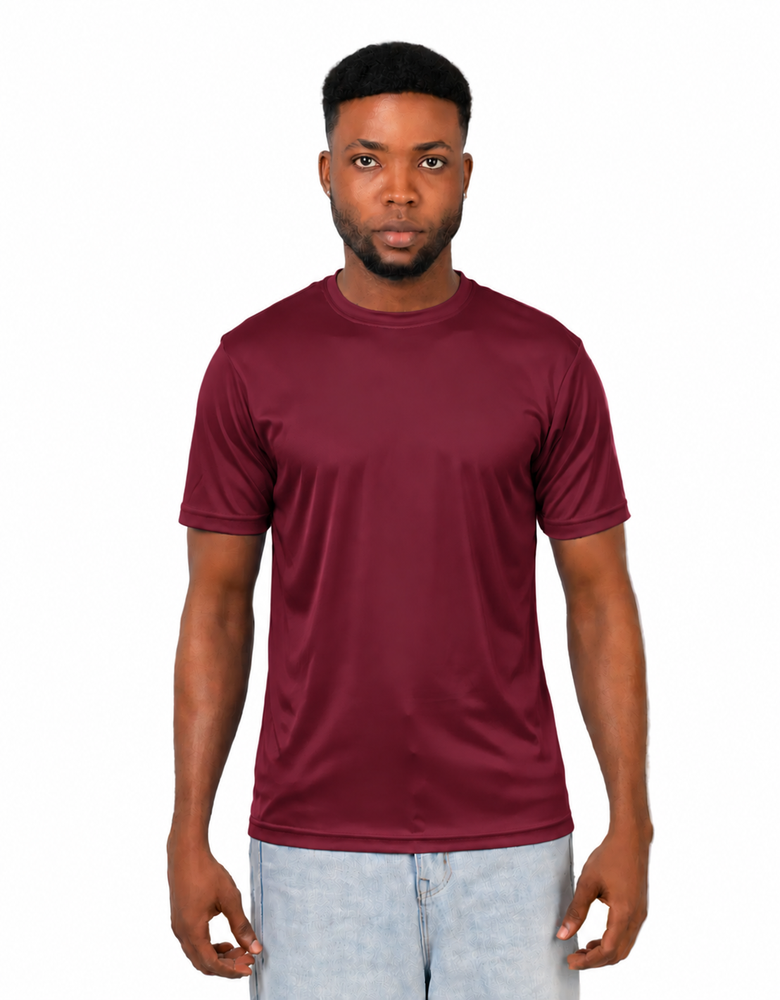 A man wearing a short-sleeve crewneck t-shirt in maroon, paired with light wash jeans, standing against a solid white background.