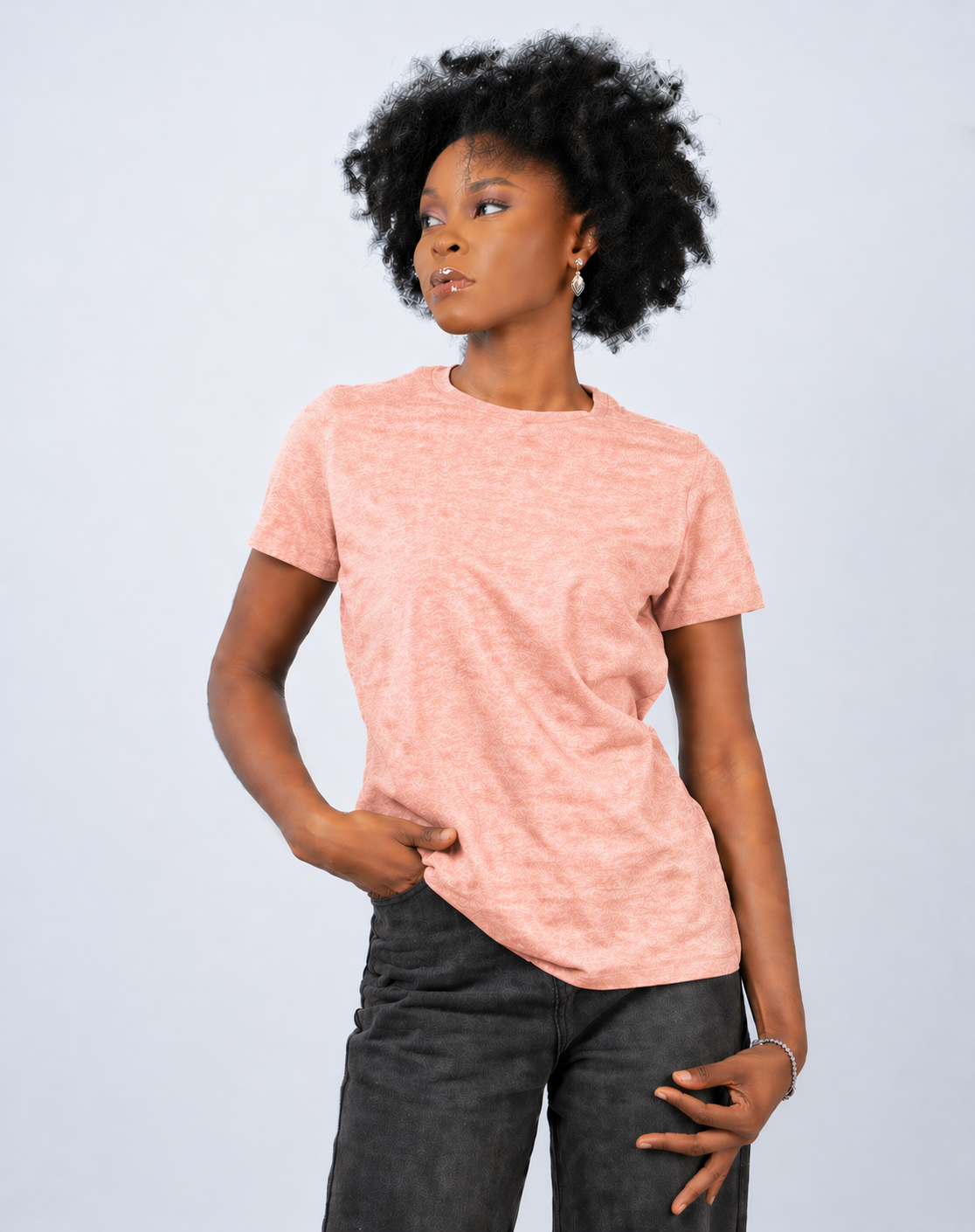 Person wearing a pink t-shirt and dark pants on a light gray background