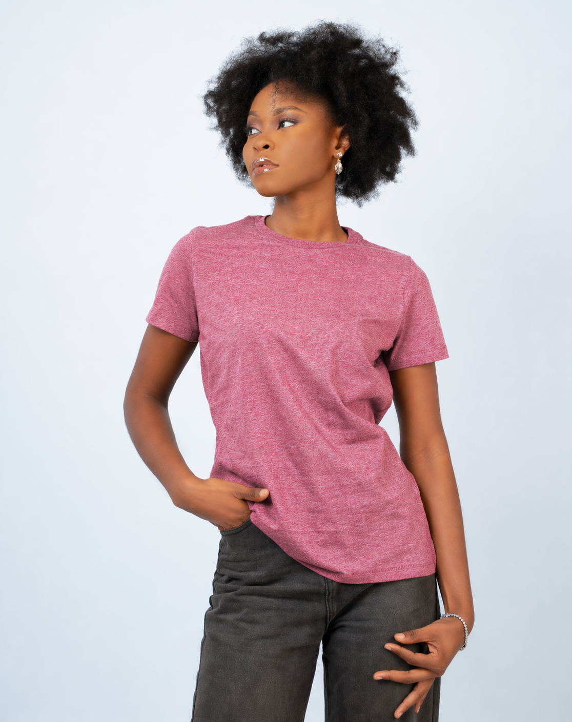 Person wearing a pink t-shirt and dark pants on a light gray background