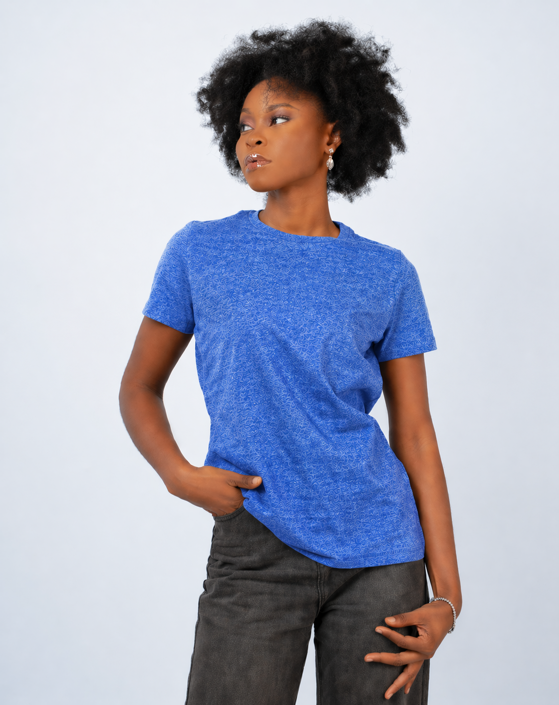 Person wearing a blue t-shirt and dark pants against a light gray background