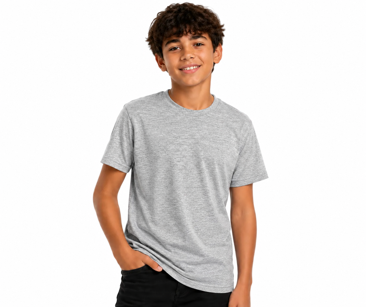 A smiling young man wearing a light gray heather crewneck t-shirt and black pants, standing against a solid white background.