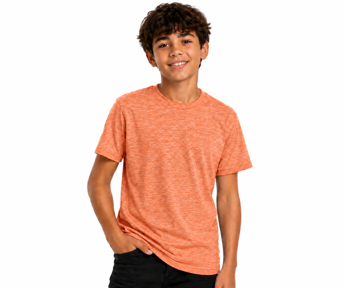 A smiling young man with curly brown hair wearing a heathered orange crewneck t-shirt and black pants, standing against a solid white background.