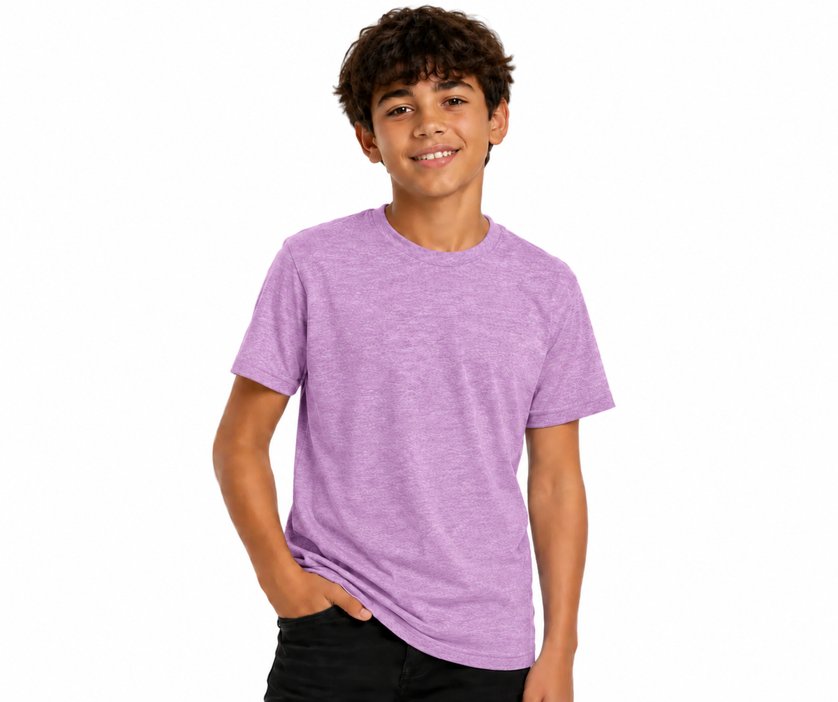 A young boy with curly brown hair smiling, wearing a heathered light purple crewneck t-shirt and black pants, photographed against a solid white background.
