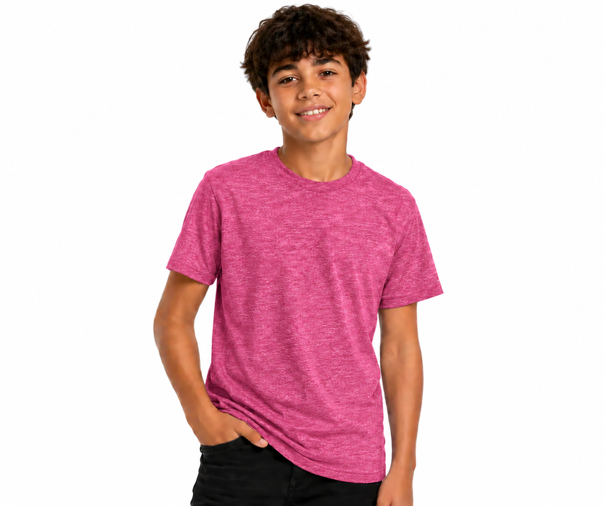 A young boy with curly brown hair smiling, wearing a heathered pink crewneck t-shirt and black pants, photographed against a solid white background.